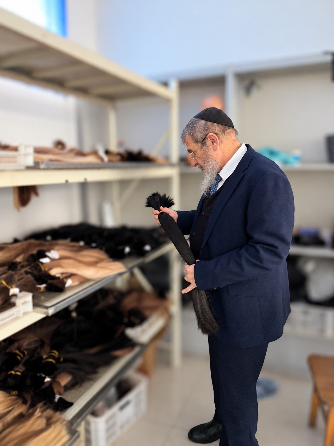 A supervising rabbi inspecting raw hair bundles on the sorting floor in Qingdao
